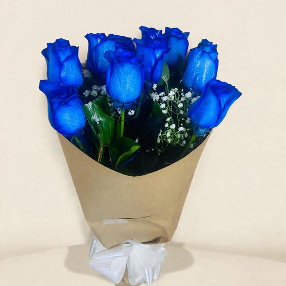A dozen blue roses with baby's breath wrapped in kraft paper with a white bow on a cream background