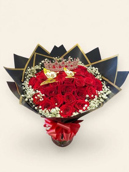 Fifty red roses with a pink tiara, golden butterflies, black and gold wrap, and a red bow