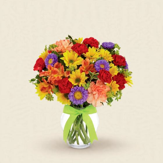Colorful bouquet of yellow daisies, red and peach carnations, purple asters and orange alstroemeria with a green satin bow in a glass vase