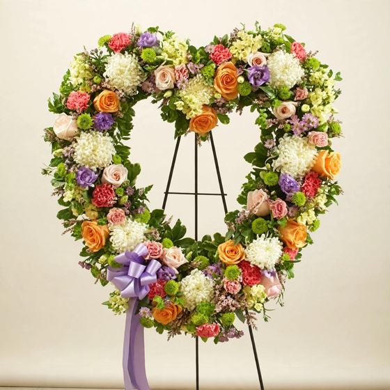 Garden of Memories Wreath with orange roses and pink and purple blooms on a cream background