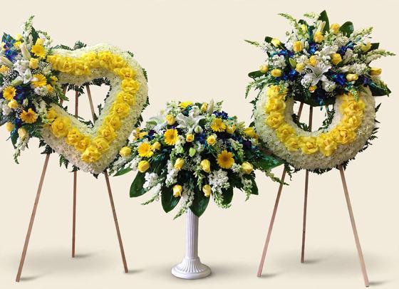 Golden Memories Funeral Set with a yellow heart wreath, a yellow and white urn arrangement, and a round yellow wreath