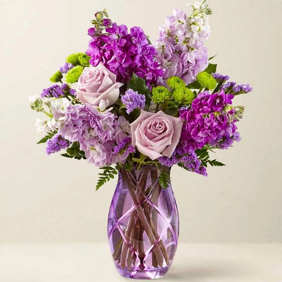 Lavender Meadow Bouquet with purple and lavender stock, lavender roses and green mums on a cream background