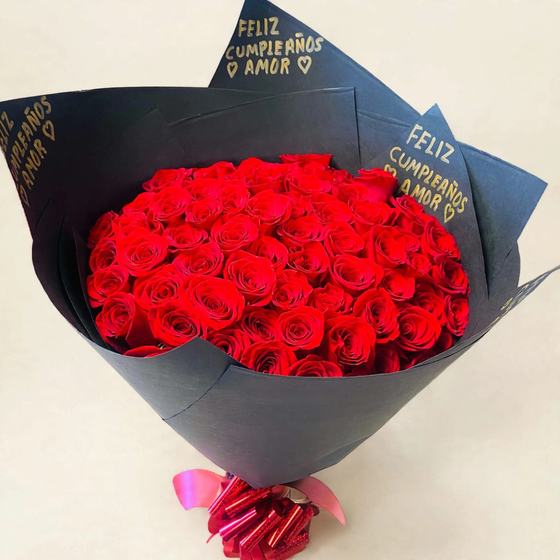 Fifty red roses in black wrap with gold lettering and a red bow on a cream background