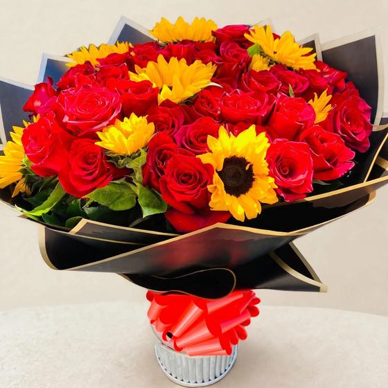 Romantic red rose and sunflower arrangement on a cream studio background