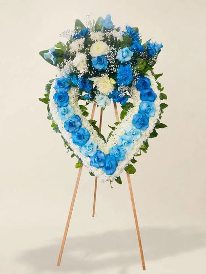 Ocean Blue Heart Wreath with blue roses, white mums and blue delphinium on a cream background