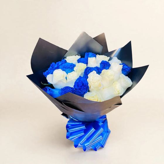 Twenty-four blue and white roses in black wrap with a blue bow on a cream background