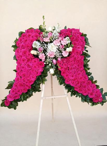 Pink Angel Wings Tribute made of hot pink carnations with a delicate pink and white heart at the center