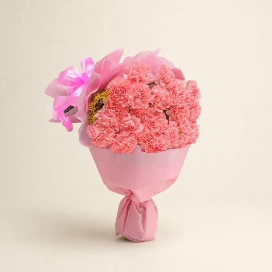 Pink carnations wrapped in soft pink paper on a cream background