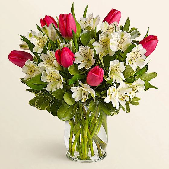 Pink tulips and white alstroemeria in a glass vase