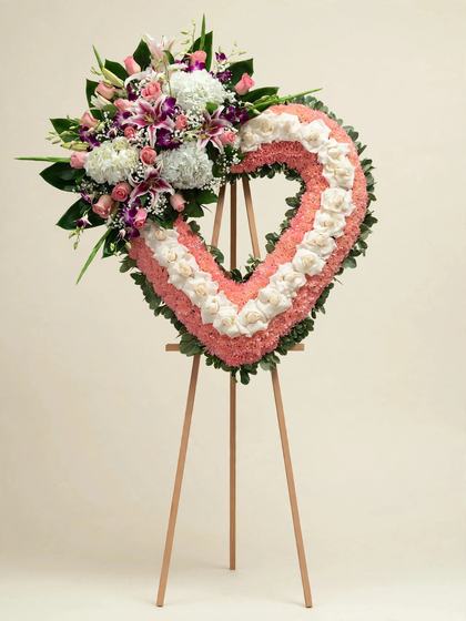 Pink and White Heart Wreath with pink and white roses, pink lilies and purple orchids on a cream background