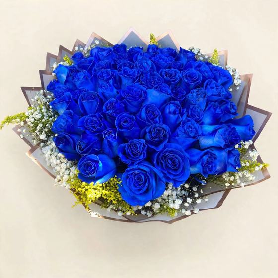 Fifty blue roses with baby's breath and yellow solidago wrapped in translucent gray paper on a cream background