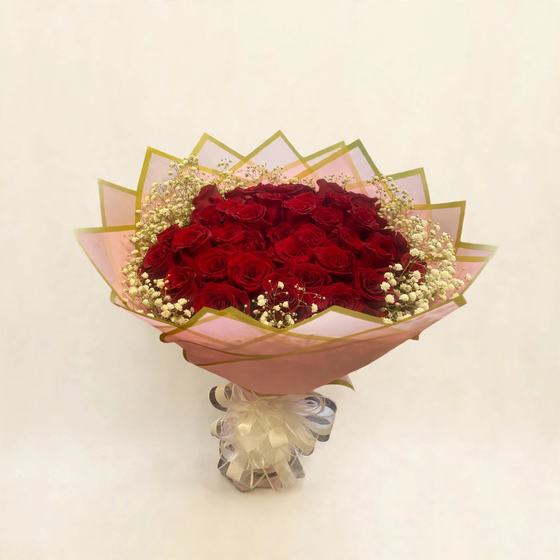 Fifty red roses with baby's breath in blush pink and gold wrap with a white bow