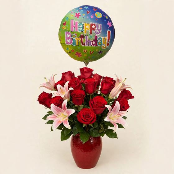 Red roses and pink and white stargazer lilies in a red vase with a Happy Birthday balloon