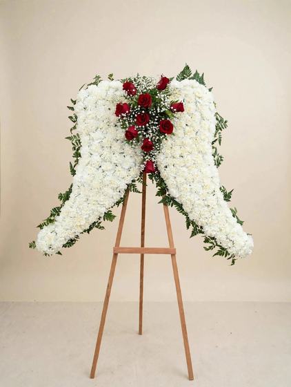White Angel Wings Tribute made of white carnations with a heart of red roses at the center