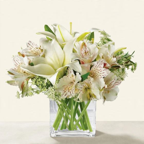 White Lily Grace Bouquet with white lilies and white alstroemeria on a cream background